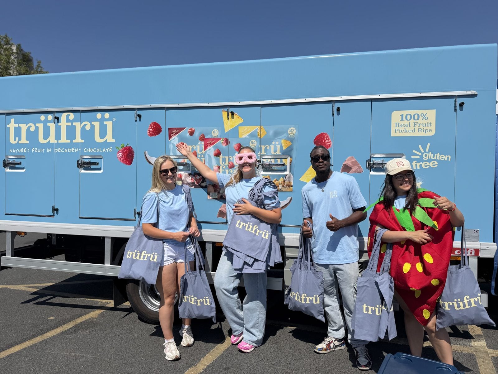 The Trü Frü team in front of the freezer van, holding tote bags.