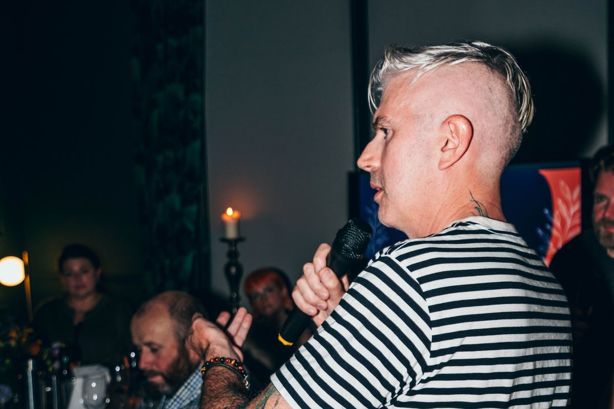 Andrew Casey speaking with a microphone at the Right Room dinner