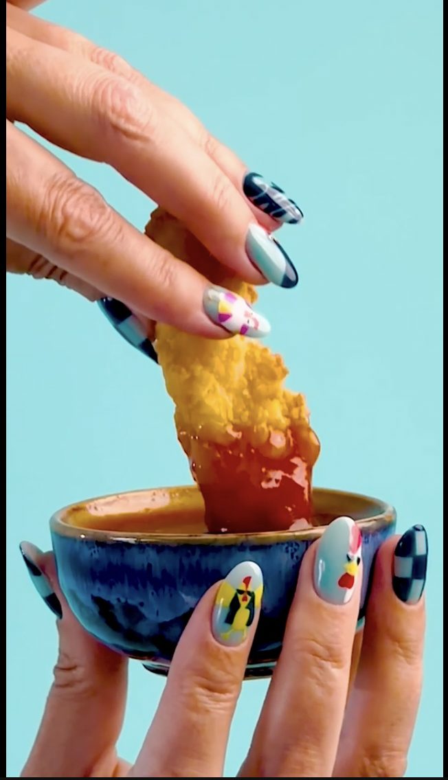 A Chicken with Attitude tender dipped in sauce.