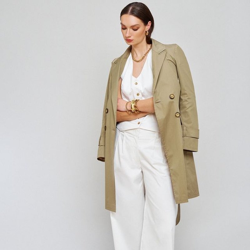 A model in an Amilli trench coat and white tailoring.
